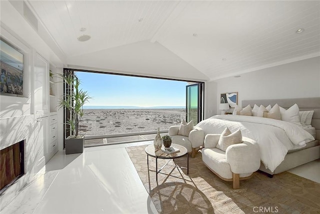 bedroom featuring a beach view, vaulted ceiling with beams, a water view, and a premium fireplace