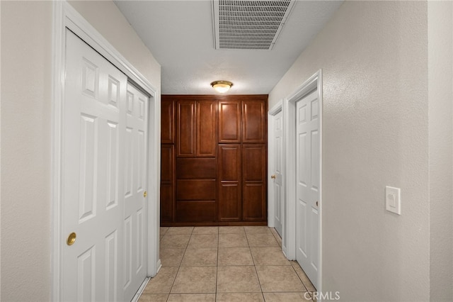 hall with light tile patterned floors