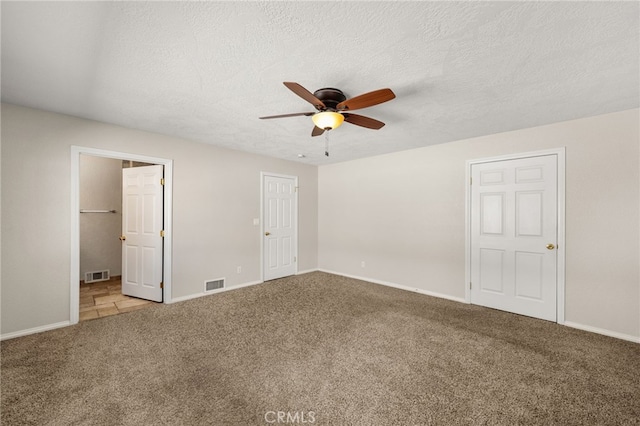 unfurnished bedroom with ceiling fan, carpet floors, and a textured ceiling