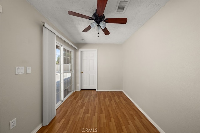 interior space featuring hardwood / wood-style flooring, ceiling fan, and a textured ceiling