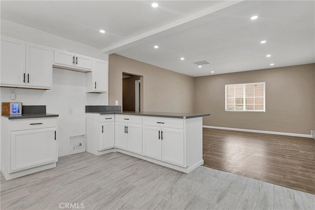 kitchen with white cabinetry, kitchen peninsula, and light hardwood / wood-style floors