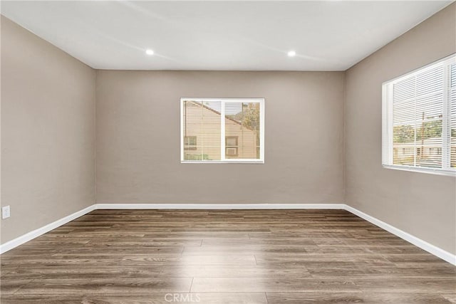 unfurnished room featuring plenty of natural light and hardwood / wood-style floors