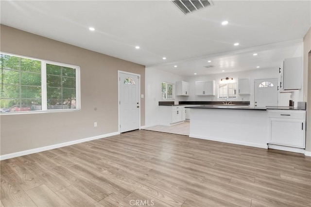 kitchen with sink, white cabinetry, and light hardwood / wood-style flooring