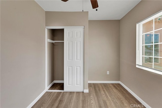 unfurnished bedroom with a closet, ceiling fan, and light wood-type flooring