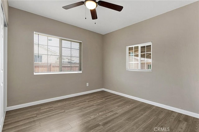 spare room with ceiling fan, hardwood / wood-style flooring, and a wealth of natural light