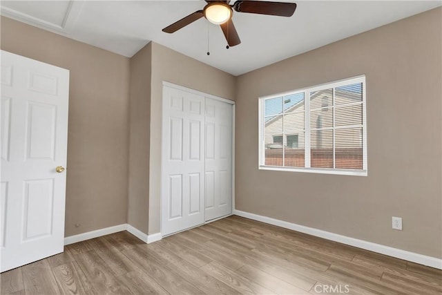 unfurnished bedroom with light hardwood / wood-style floors, a closet, and ceiling fan