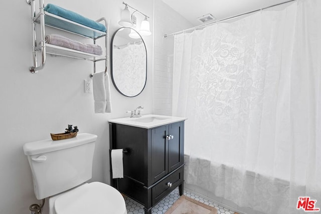 bathroom with tile patterned flooring, vanity, and toilet