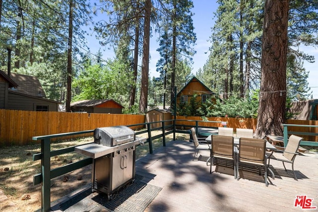 deck featuring area for grilling and a storage shed