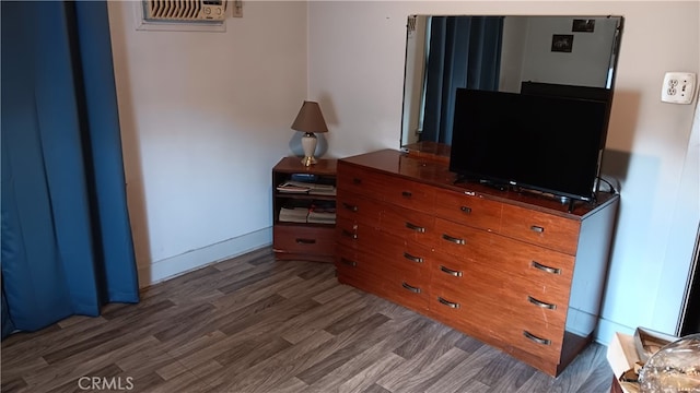 bedroom with dark wood-type flooring and a wall unit AC