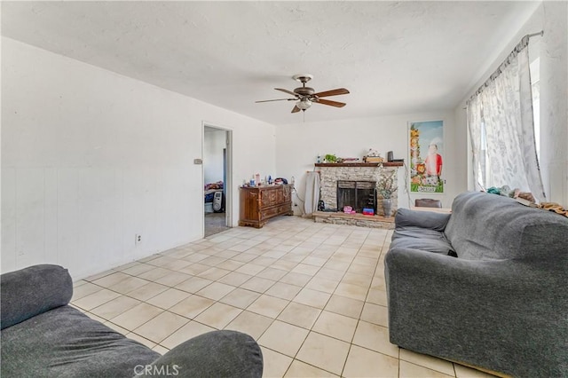 tiled living room with ceiling fan and a fireplace