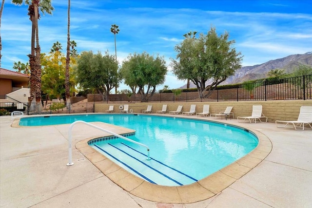 view of swimming pool with a mountain view and a patio area