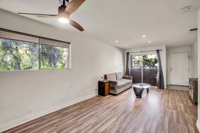 living room with light wood-type flooring and ceiling fan