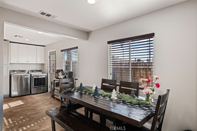 dining space with separate washer and dryer and wood-type flooring