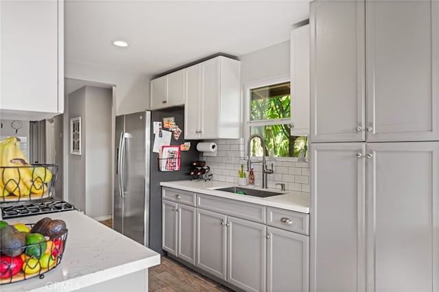 kitchen featuring decorative backsplash, sink, stainless steel fridge, gray cabinets, and dark hardwood / wood-style floors