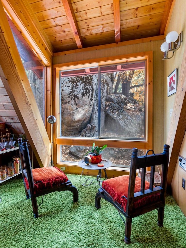 living area with beam ceiling, wooden ceiling, and carpet