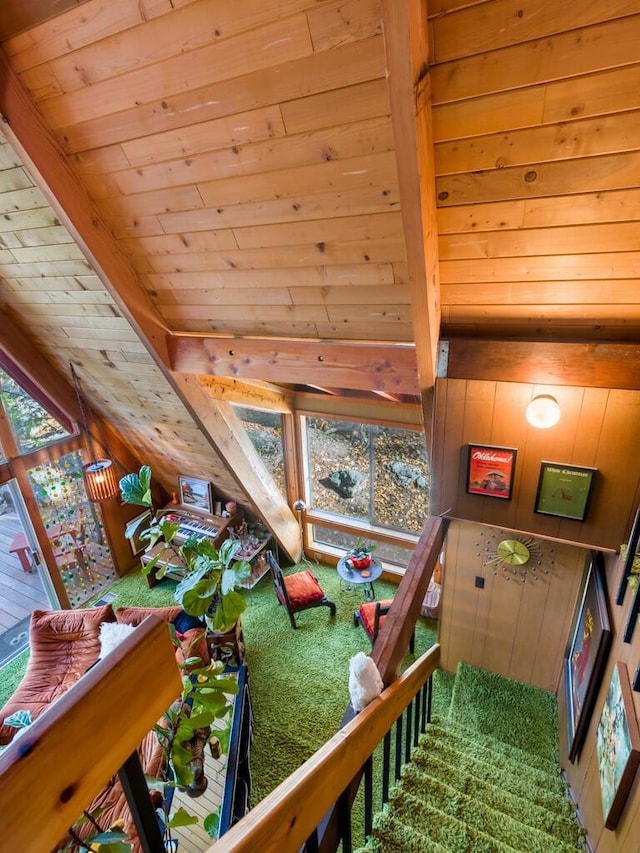 rec room with a healthy amount of sunlight, wooden ceiling, beam ceiling, and wood walls