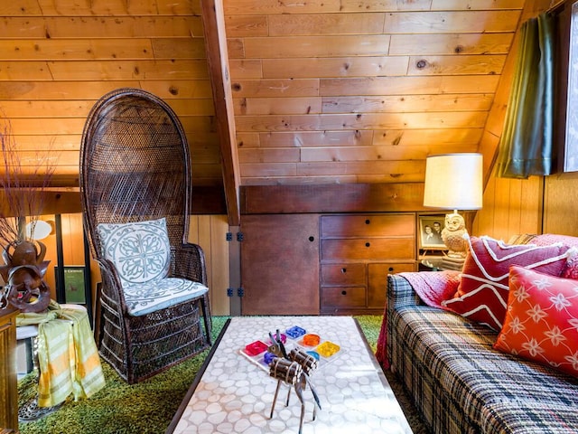 living area with beam ceiling, carpet flooring, and wooden walls