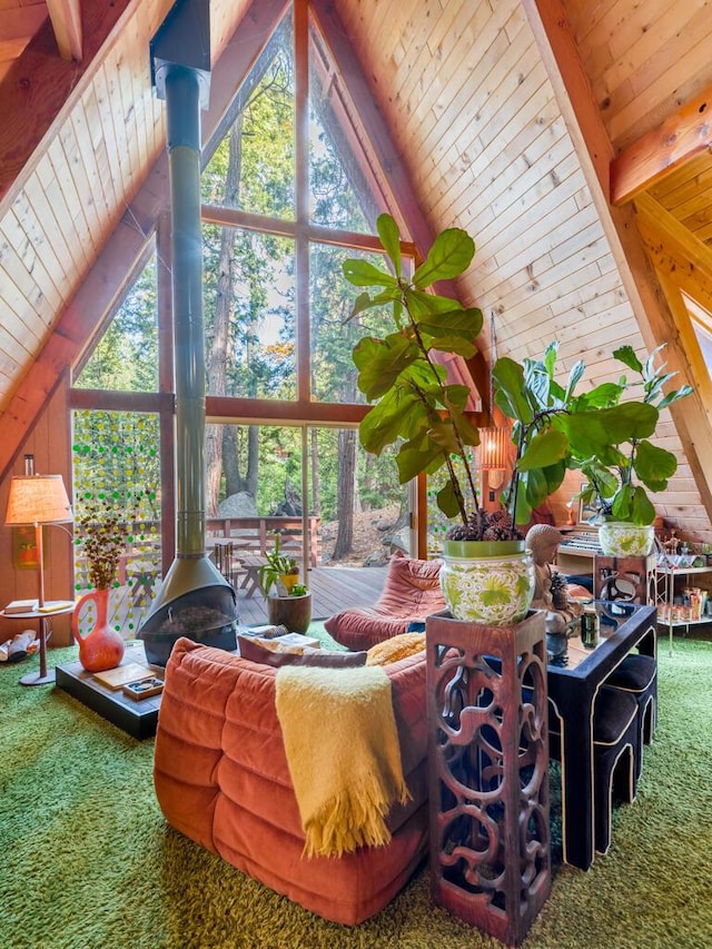 living room featuring beamed ceiling, carpet, a wood stove, and wood ceiling