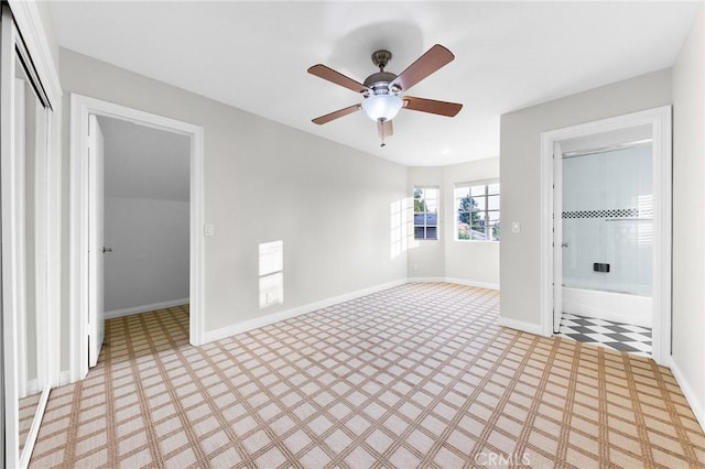 unfurnished bedroom featuring ceiling fan, a walk in closet, connected bathroom, and a closet