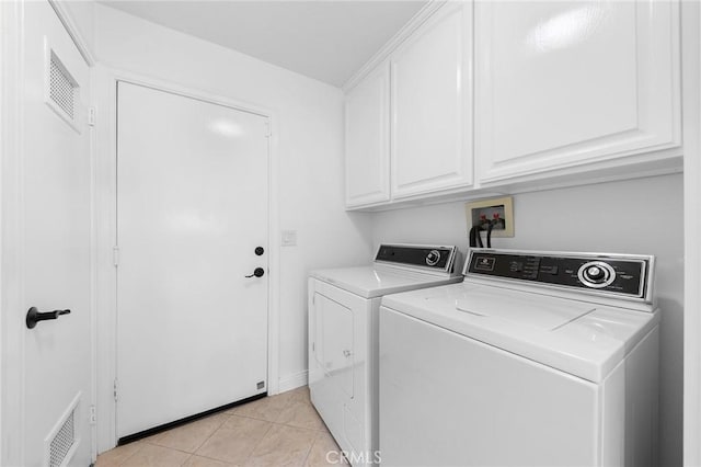 washroom with cabinets, light tile patterned floors, and separate washer and dryer