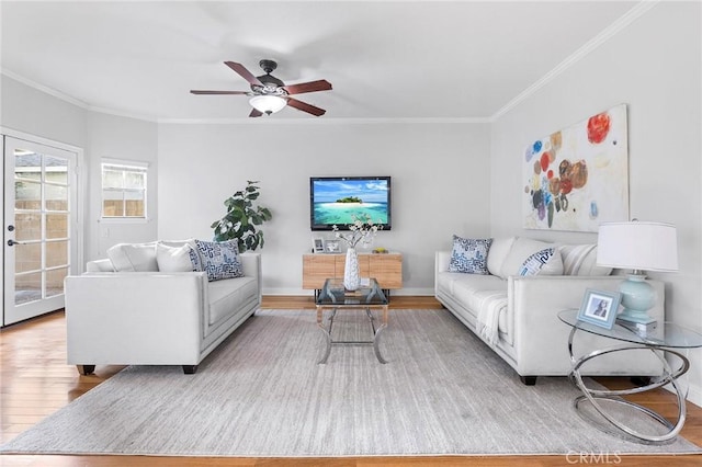 living room with light hardwood / wood-style floors, ceiling fan, and ornamental molding