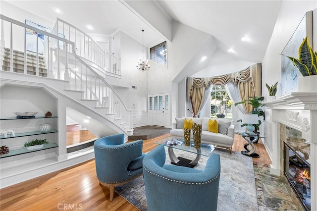 living room featuring hardwood / wood-style floors, a towering ceiling, and a chandelier