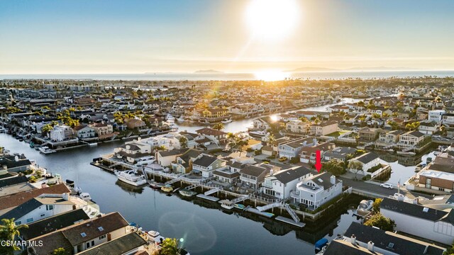 aerial view at dusk featuring a water view