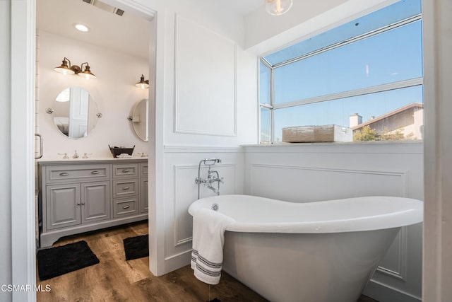 bathroom featuring vanity, wood-type flooring, and a tub