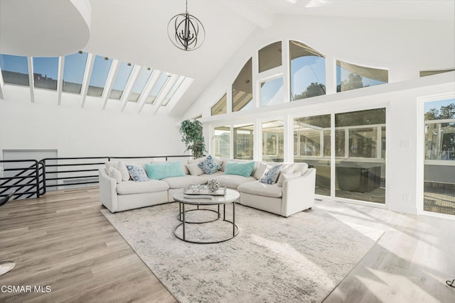 living room with beamed ceiling, high vaulted ceiling, hardwood / wood-style floors, and an inviting chandelier