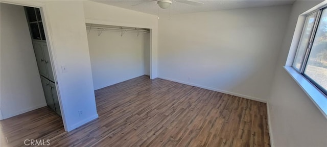 unfurnished bedroom with ceiling fan, a closet, and dark hardwood / wood-style floors