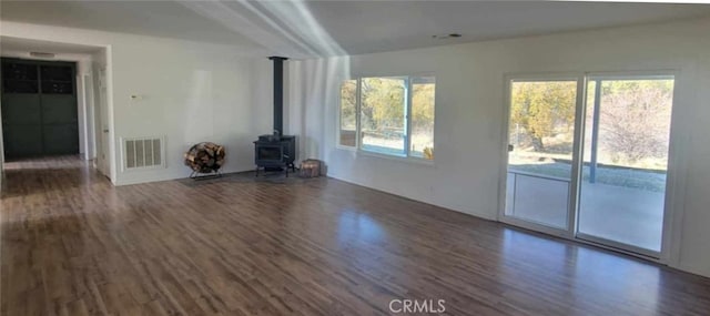 unfurnished living room with dark hardwood / wood-style flooring and a wood stove