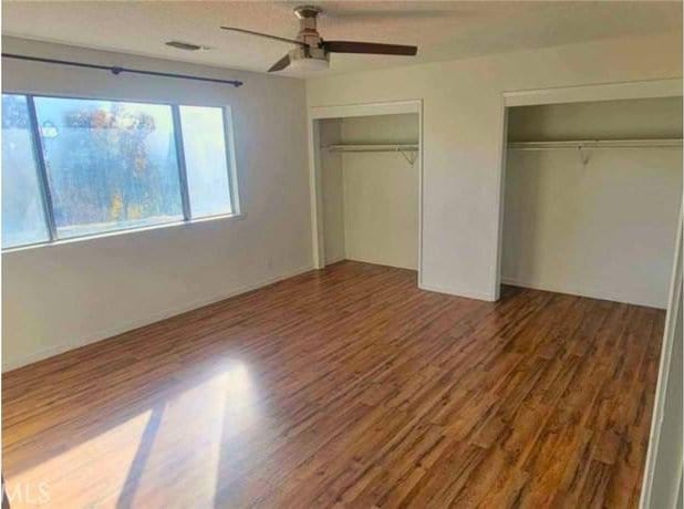 unfurnished bedroom featuring ceiling fan and wood-type flooring