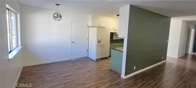 kitchen with dark wood-type flooring, white fridge with ice dispenser, white cabinets, and hanging light fixtures