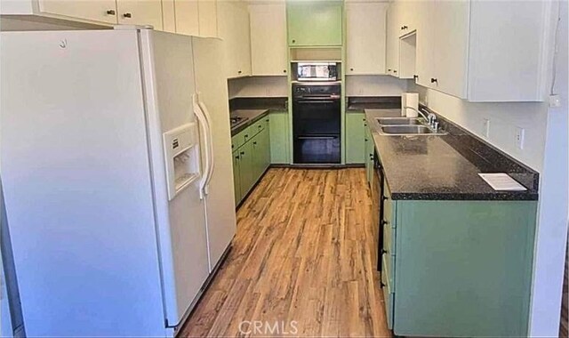 kitchen featuring white fridge with ice dispenser, white cabinets, light hardwood / wood-style floors, and sink