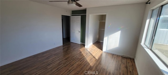 unfurnished bedroom featuring a closet, ceiling fan, and dark hardwood / wood-style flooring