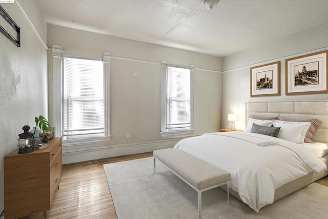 bedroom with light hardwood / wood-style flooring and multiple windows