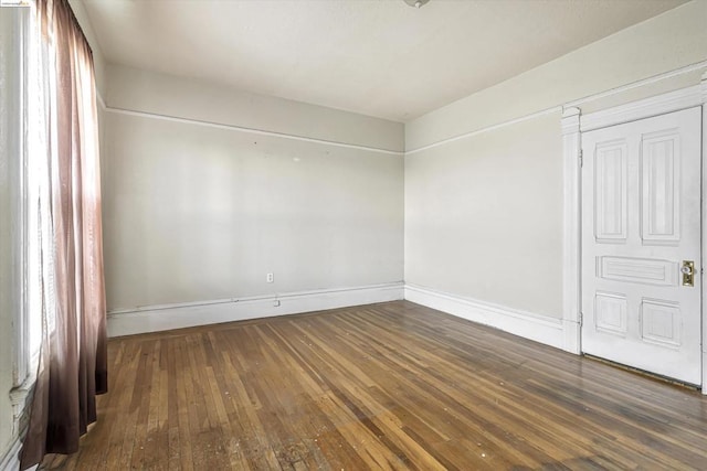 empty room with dark hardwood / wood-style flooring