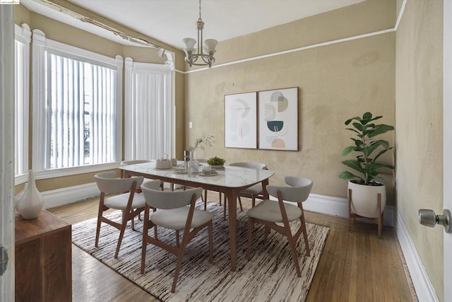 dining room featuring wood-type flooring and an inviting chandelier