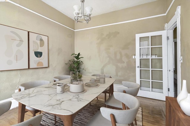 dining area featuring wood-type flooring and an inviting chandelier