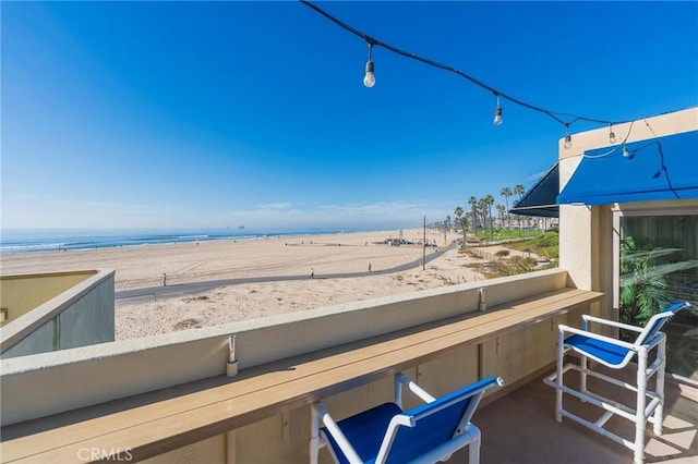 balcony with a beach view and a water view