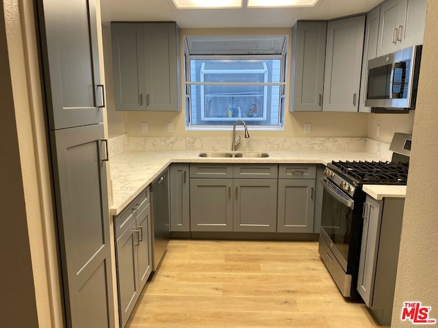 kitchen featuring appliances with stainless steel finishes, gray cabinetry, and sink