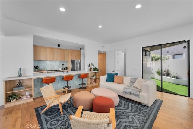 living room with sink and light wood-type flooring