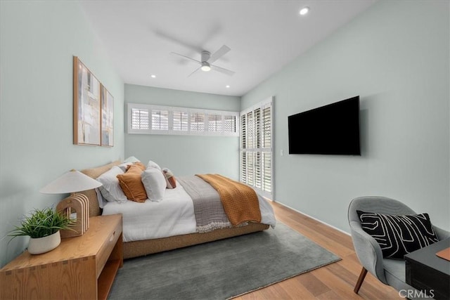 bedroom featuring multiple windows, wood-type flooring, and ceiling fan