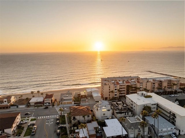 aerial view at dusk featuring a water view