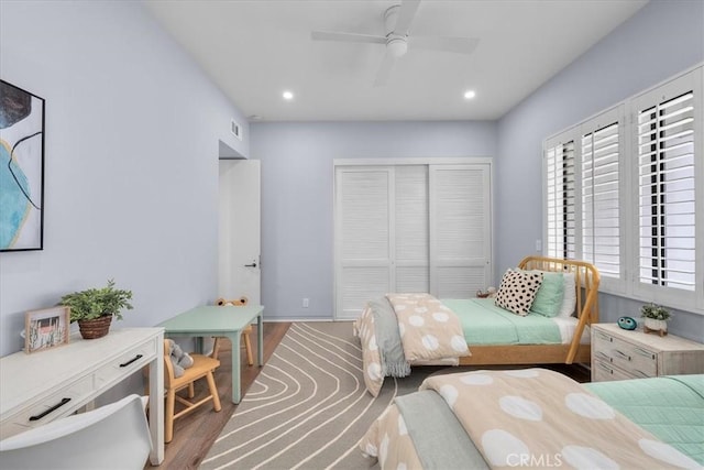 bedroom featuring hardwood / wood-style flooring, ceiling fan, and a closet