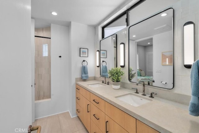 bathroom featuring vanity, a tile shower, and tile patterned floors