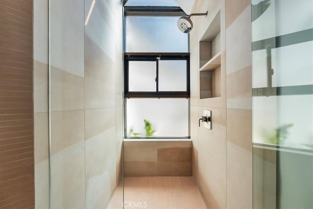 bathroom with tile walls and a tile shower