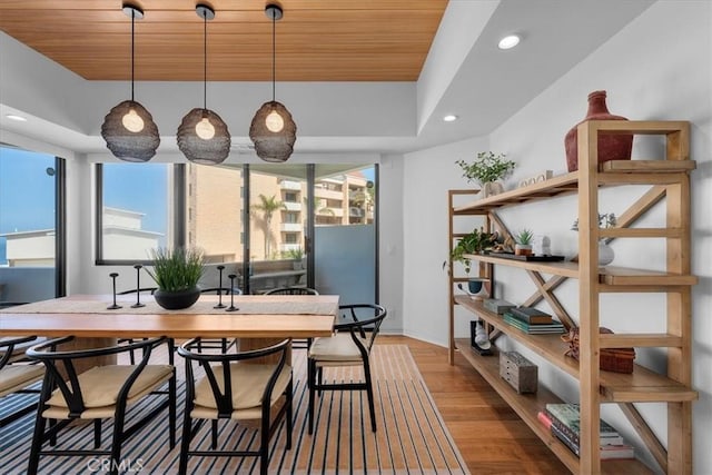 dining room with wood ceiling, a wealth of natural light, and light hardwood / wood-style floors