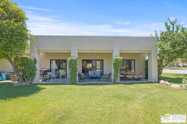 rear view of property with a yard and a patio area