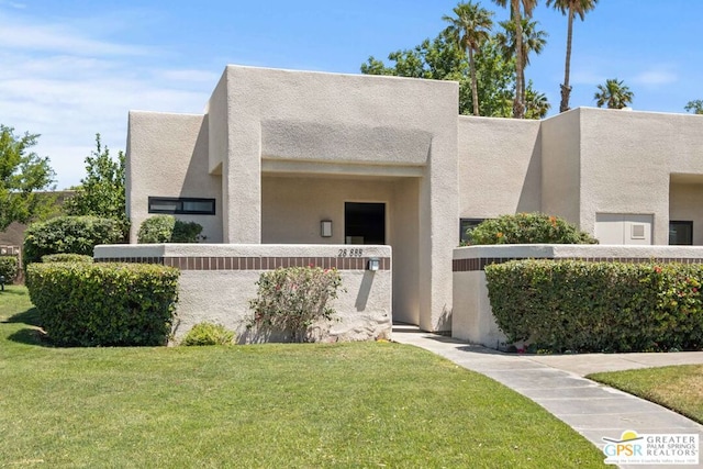 pueblo-style home featuring a front yard